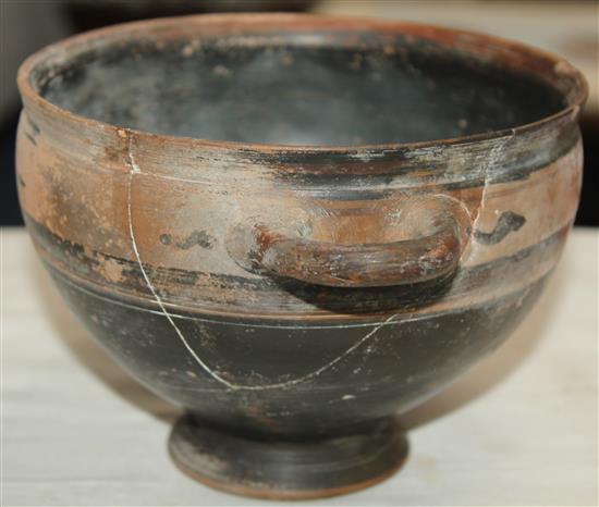 A Greek black slip decorated skyphos, Apulia, c.4th century BC, 22.5cm, broken and re-assembled